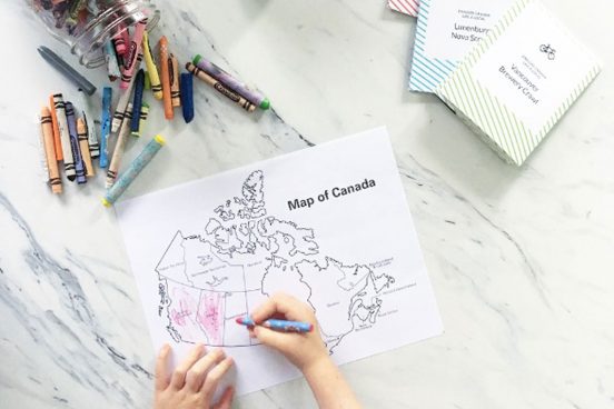 Canada Travel post. Kid hands colouring a map of Canada.